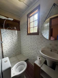 a bathroom with a toilet and a sink and a mirror at Chalé Retiro Real in Ouro Preto