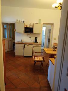 a kitchen with white cabinets and a table and a chair at Bacchus-hof in Báta