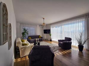 a living room with a couch and chairs and a tv at White Ribbon Prizren in Prizren