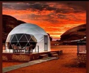 a painting of a dome shaped building with a sunset at Ain Rum Luxury Camp in Wadi Rum