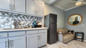 a kitchen with white cabinets and a black refrigerator at Andros Waterside Retreat in Deep Creek
