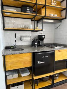 a small kitchen with wooden cabinets and a black dishwasher at Studio Mirador in San Carlos de Bariloche