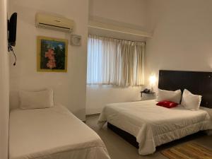 a hotel room with two beds and a window at Los Lirios Hotel Merida in Mérida +14 photos
