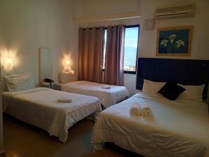 a hotel room with two beds with towels on them at Los Lirios Hotel Merida in Mérida