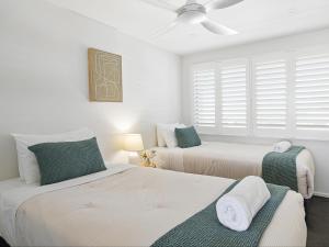 a bedroom with two beds and a window at Wharf Lodge River View Apartment in Maroochydore