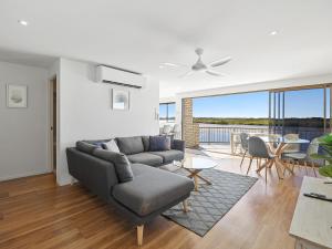 a living room with a couch and a table at Wharf Lodge River View Apartment in Maroochydore