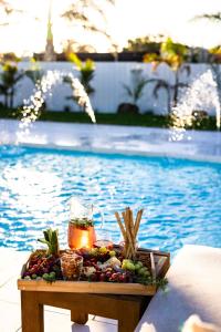 a tray of fruit and a drink on a table next to a pool at Barossa Palms Motel in Nuriootpa