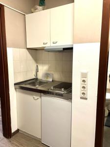 a kitchen with white cabinets and a sink at modernes gemütliches Apartment in Gießen