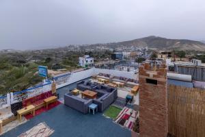 a balcony with tables and chairs on top of a building at Taghazout Waves Surf camp & Hotel in Aourir