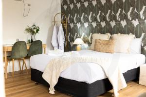 a bedroom with a bed and a desk and chairs at Barossa Palms Motel in Nuriootpa +98 photos