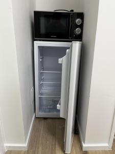 a refrigerator with a microwave on top of it at Gästezimmer 21qm im Casa Kirchweg in Gladbach