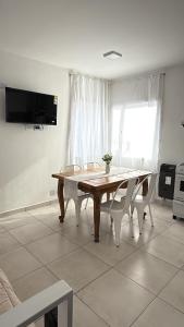a dining room with a table and chairs and a tv at Amelie 2 in General Roca