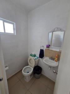 a white bathroom with a toilet and a sink at Casa VP en Fraccionamiento in Ciudad Acuña