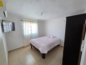 a small bedroom with a bed and a window at Casa VP en Fraccionamiento in Ciudad Acuña
