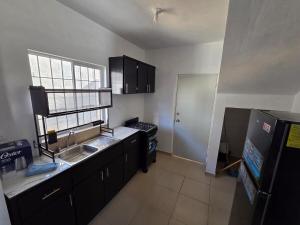 a small kitchen with a sink and a refrigerator at Casa VP en Fraccionamiento in Ciudad Acuña
