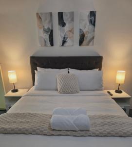 a bedroom with a bed with two lamps and two towels at Flaxton Country Lodge in Flaxton +3 photos