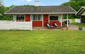 a red house with two chairs in a yard at Golfparken in Aabenraa