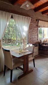 a dining room with a wooden table and chairs at Complejo Tiú Mayú in La Granja