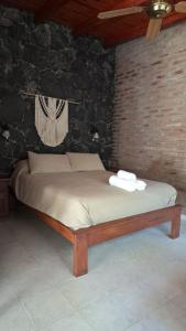 a bed in a room with a brick wall at Complejo Tiú Mayú in La Granja