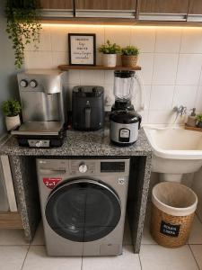 a kitchen counter with a blender on top of a washing machine at Recanto Augusta in Londrina