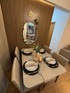 a dining table with chairs and a mirror at Recanto Augusta in Londrina