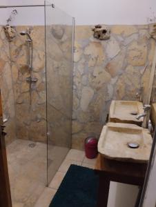 a bathroom with two sinks and a shower at Le Courbaril in Le Gosier