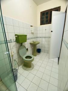 a bathroom with a green toilet and a sink at Suite Aconchegante com ampla Area externa - Green in São Luís