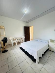 a bedroom with a bed and a table and chairs at Suite Aconchegante com ampla Area externa - Green in São Luís