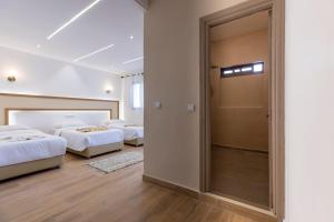 a bedroom with two beds and a sliding door at Taghazout Waves Surf camp & Hotel in Aourir