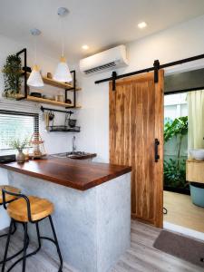 a kitchen with a counter and a wooden door at How Hide Homestay in Ban Tha Makham