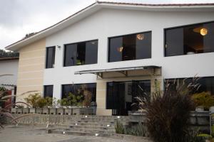 a white building with black windows at Los Lirios Hotel Merida in Mérida