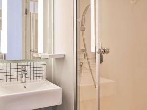 a bathroom with a sink and a shower at ibis budget Saint-Maurice in Saint-Maurice
