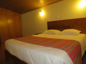 サン・ヴィセンテにあるChalé Da Melariaのベッドルーム1室(白いシーツと枕のベッド1台付)
