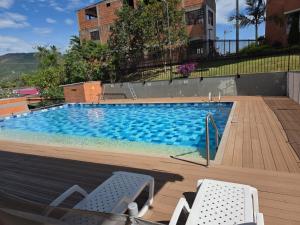 a large swimming pool with two lawn chairs in front of it at Espectacular apartamento en Guaduas in Guaduas