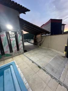 a swimming pool in front of a building at Coffehouse - Casa com Piscina in São Vicente