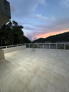 a balcony with a chair on the roof of a building at Coffehouse - Casa com Piscina in São Vicente