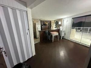 a living room with a kitchen and a table and chairs at Coffehouse - Casa com Piscina in São Vicente