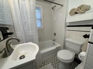 a white bathroom with a toilet and a sink at Comfortable 4 Bed Home close to Gillette in Foxborough