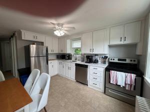 a kitchen with white cabinets and stainless steel appliances at Comfortable 4 Bed Home close to Gillette in Foxborough +12 photos