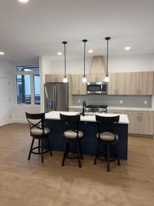 a kitchen with three bar stools and a counter top at Coral Sands in Seaside Heights