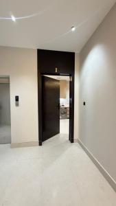 a hallway with a black door in a building at نُزل البدر - غرفة و صالة دخول ذاتي in Al Kharj