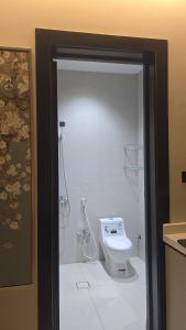 a bathroom with a toilet and a shower with at نُزل البدر - غرفة و صالة دخول ذاتي in Al Kharj +7 photos