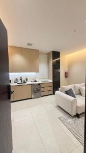 a living room with a couch and a kitchen at نُزل البدر - غرفة و صالة دخول ذاتي in Al Kharj