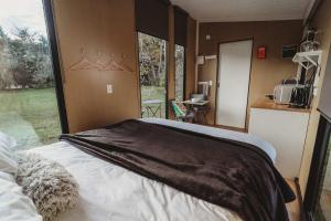 a bedroom with a bed in a room with a window at Matariki Akura by Tiny Away in Masterton
