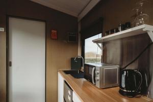 a kitchen with a microwave and a counter top at Matariki Akura by Tiny Away in Masterton