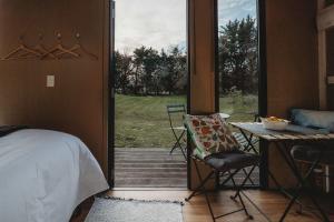 a bedroom with a door open to a patio at Matariki Akura by Tiny Away in Masterton +23 photos