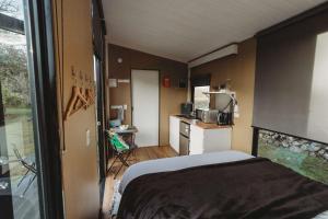 a small room with a bed and a kitchen at Matariki Akura by Tiny Away in Masterton