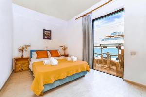 a bedroom with a bed with a view of the ocean at Hotel Anatoli Apartments in Stalís