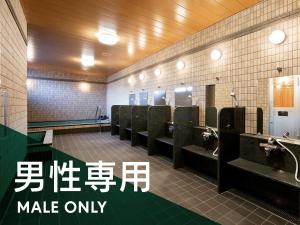 a bathroom with sinks and toilets with writing on the wall at The Kato Hotel in Tokai