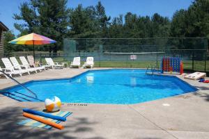 a swimming pool with a volley ball and an umbrella at New, condo stunning Lake View in Bellaire
